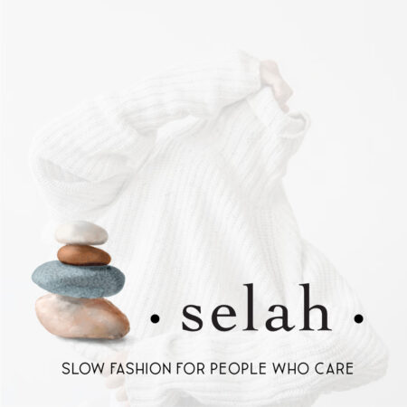 The new Selah rock logo stack is shown over a woman putting on a white sweater.