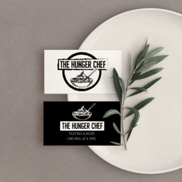 The Hunger Chef new brand and logo are printed on business cards and balanced on the edge of a platter with an olive branch.