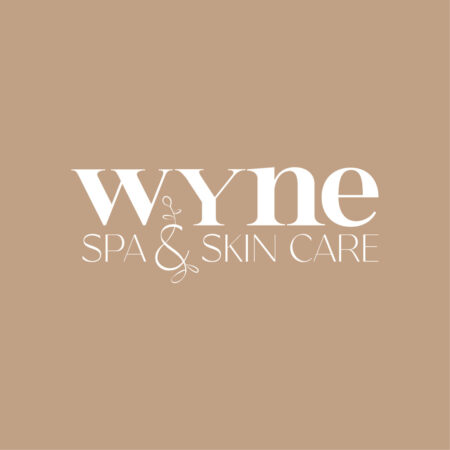 Wyne spa and skin care logo in white on a beige background. The logo is light and organic with a hand drawn floral vine.